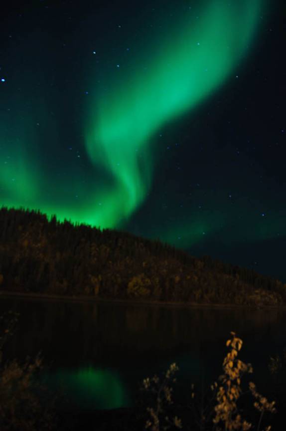 As cores da Aurora reflerem no Yukon River, em Dawson City, no noroeste do Canadá